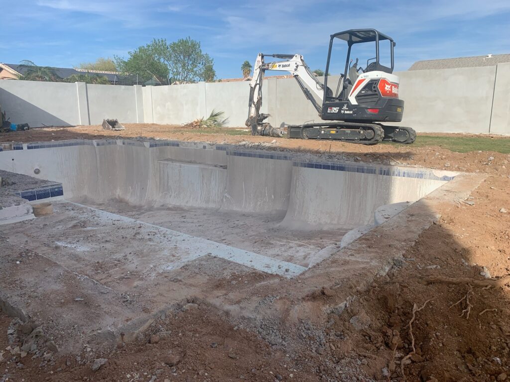 Pool renovation in progress with excavation and removal of old surface