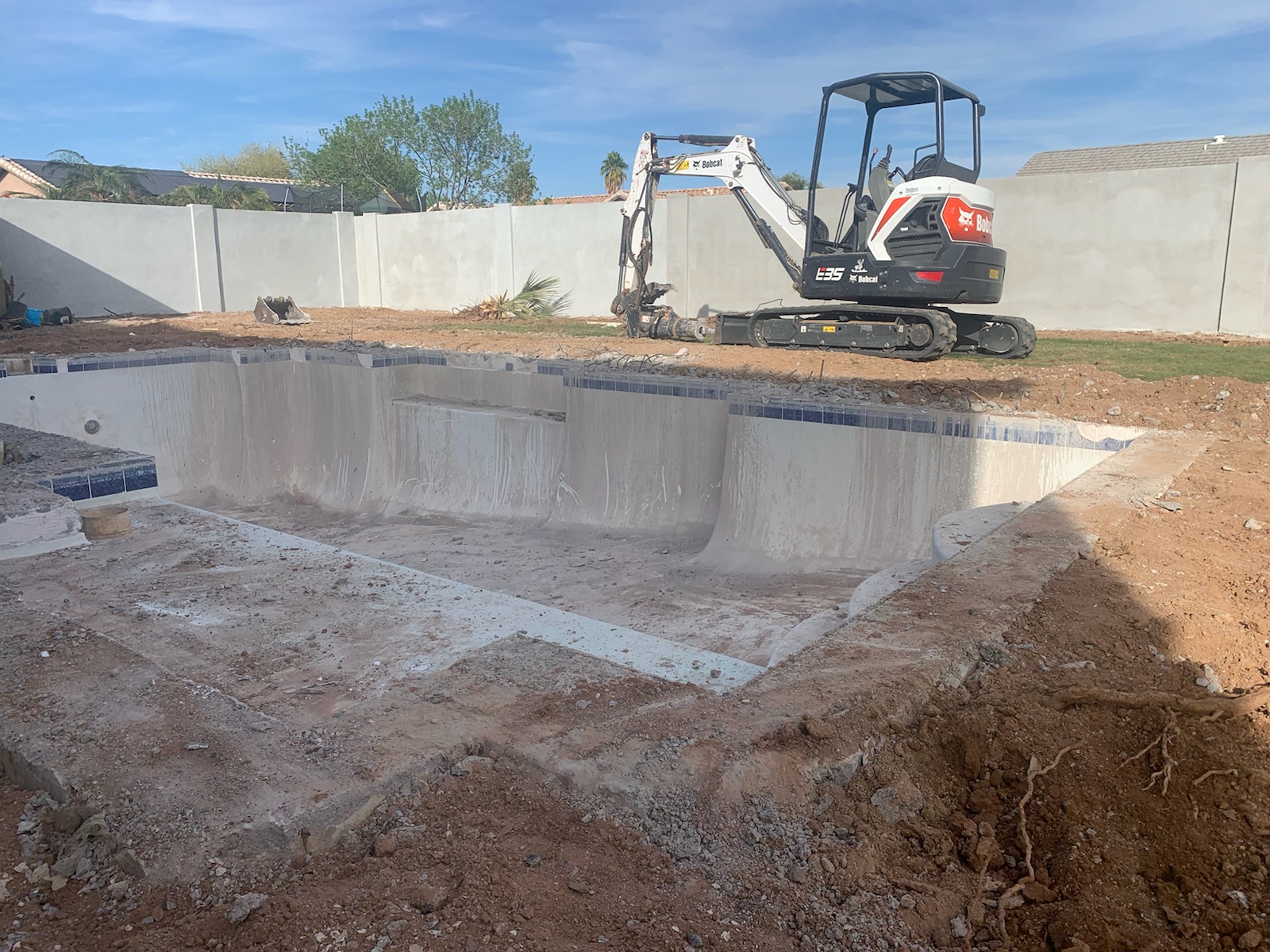Pool renovation in progress with excavation and removal of old surface