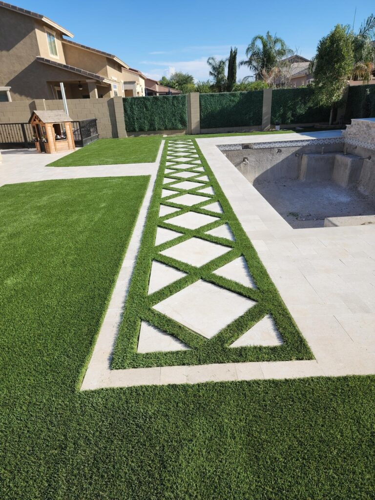 Backyard turf and stone walkway design near pool