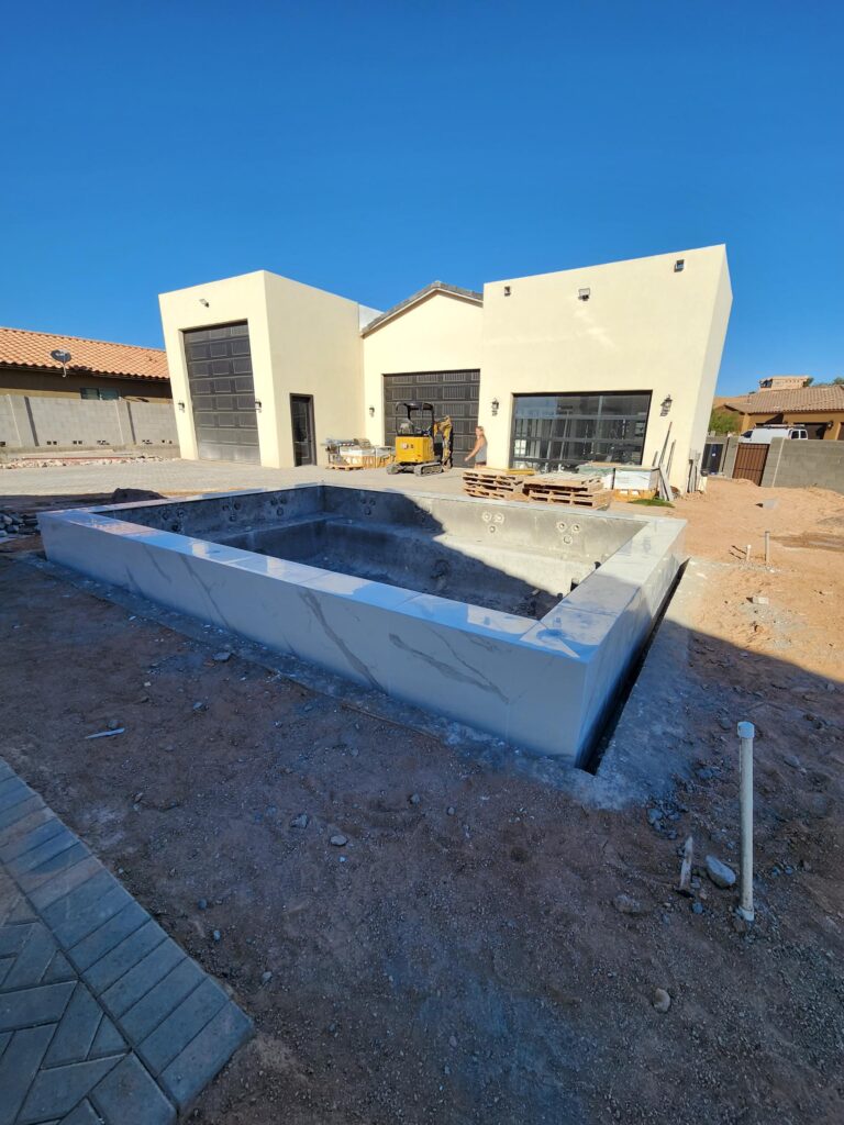 Custom pool build underway with marble tile finish and modern design