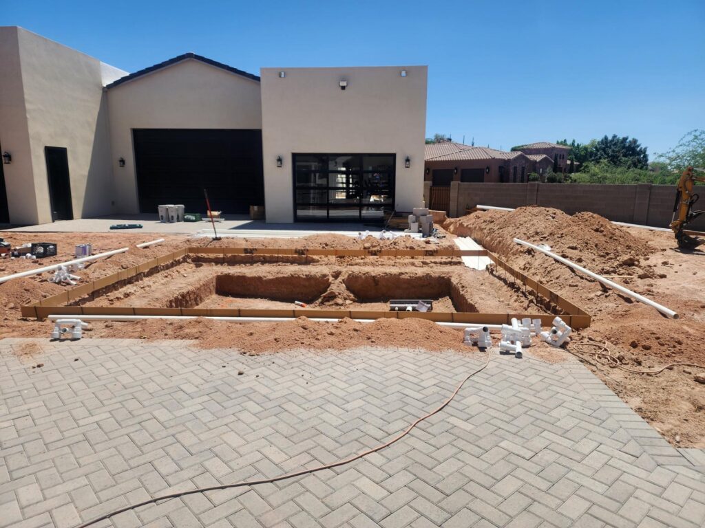 New pool digging with early piping and form setup during Mesa backyard project