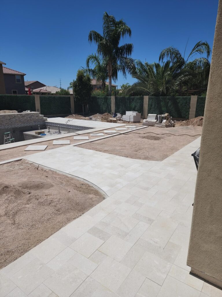 Travertine paver layout and pool deck construction