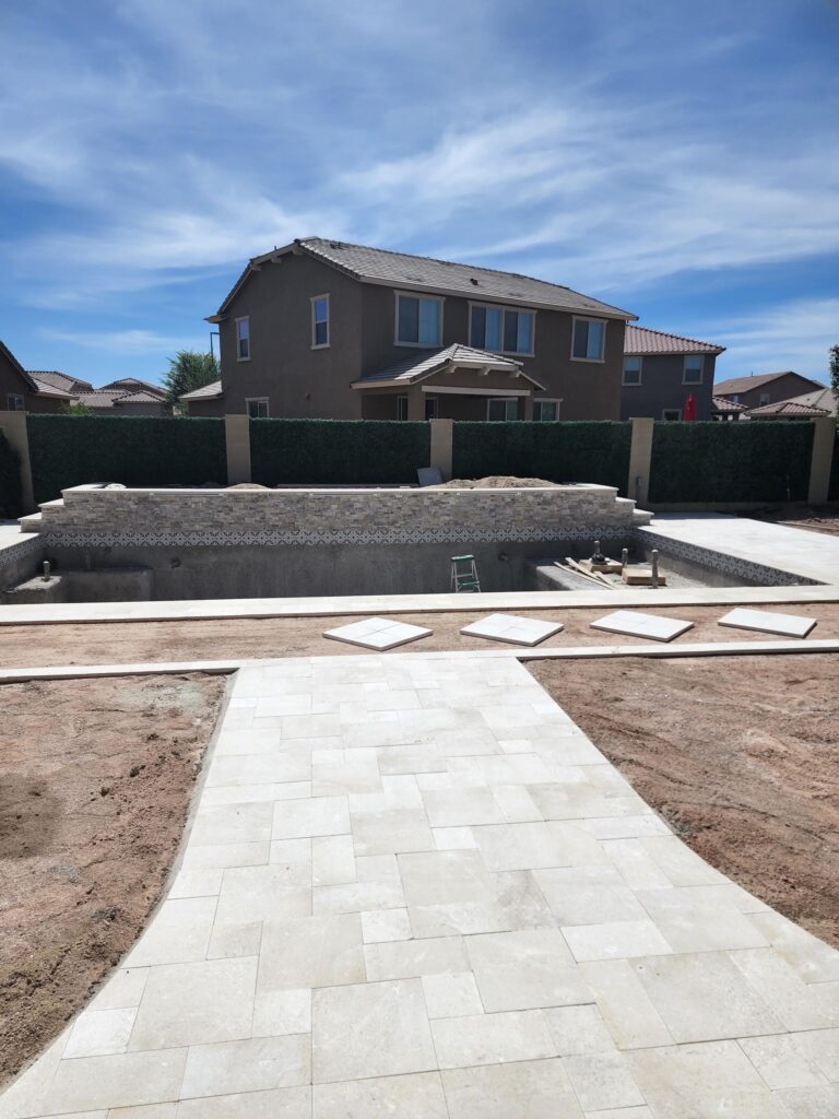 Travertine pool deck and hardscape installation in progress