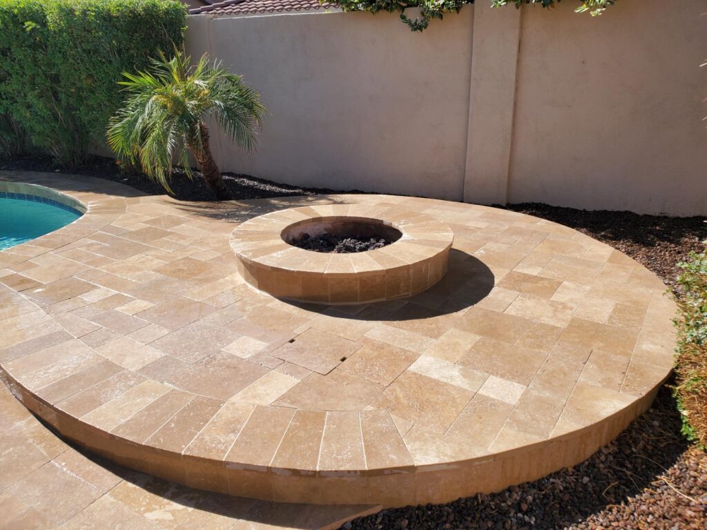 Travertine poolside fire pit with curved patio design