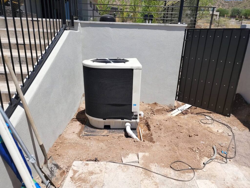 Pool heat pump installation beside backyard pool area