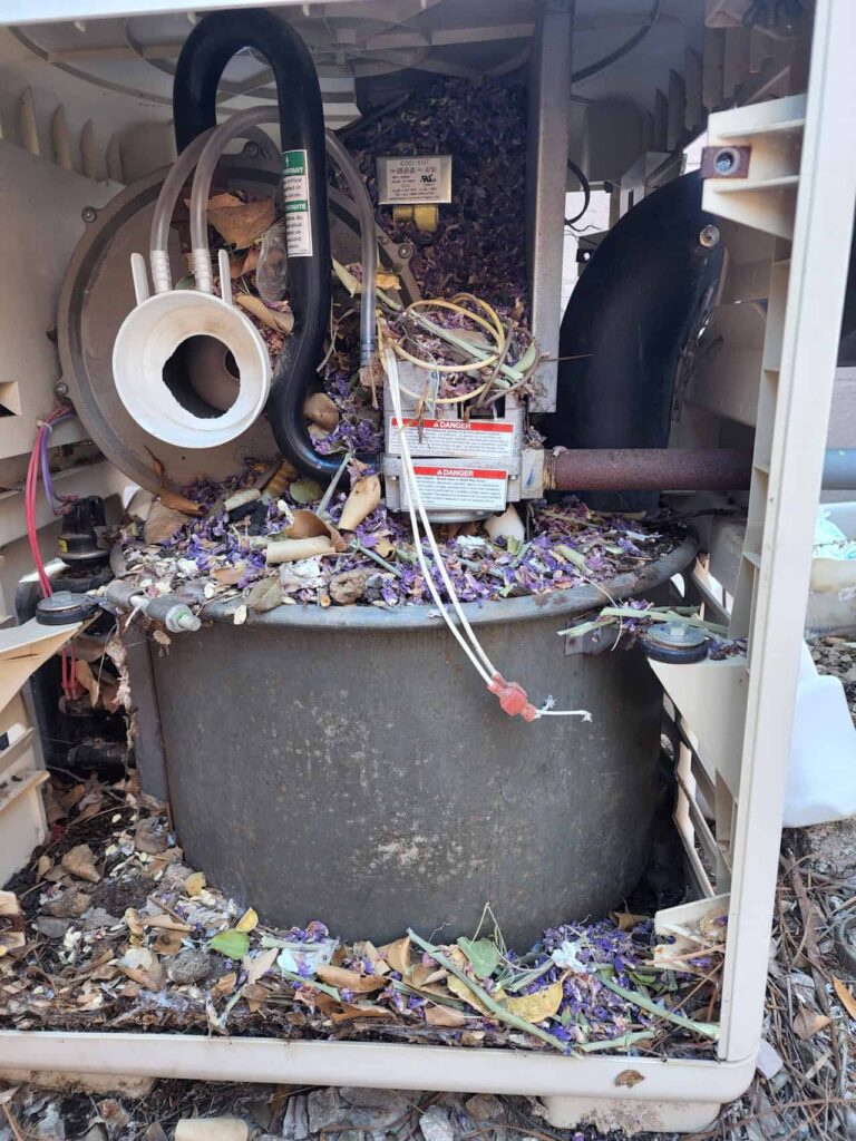 Pool heater repair showing internal cleanout and debris